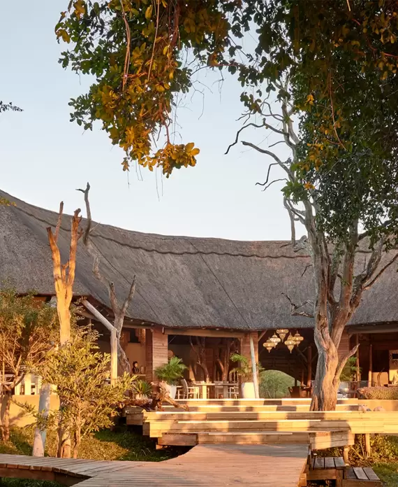 Victoria Falls River Lodge in Zimbabwe, a luxury safari lodge with thatched roofs and open-air design along the Zambezi River.