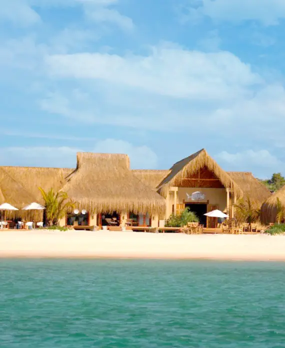 Azura Benguerra Island resort in Mozambique, featuring thatched beachfront villas on white sandy shores with clear turquoise waters.