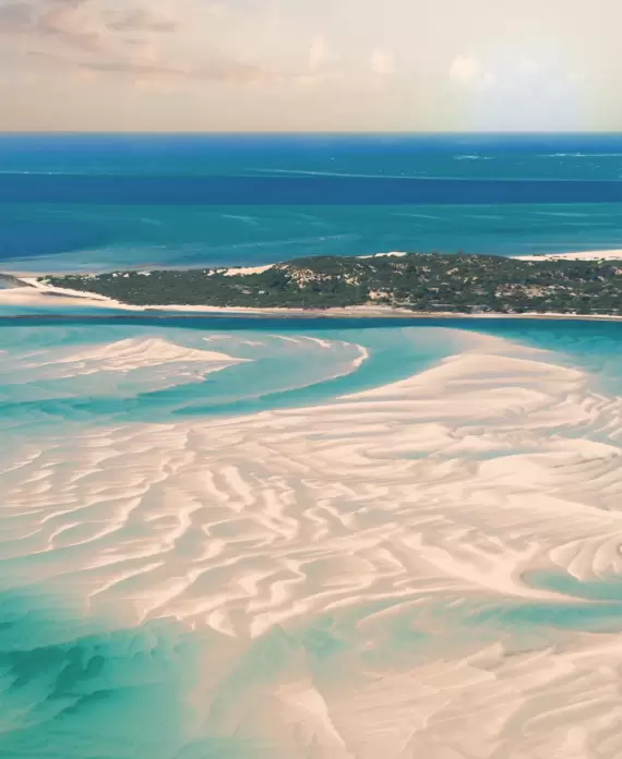 Expansive aerial view of the pristine sandbanks and turquoise waters of the Bazaruto Archipelago in Mozambique.
