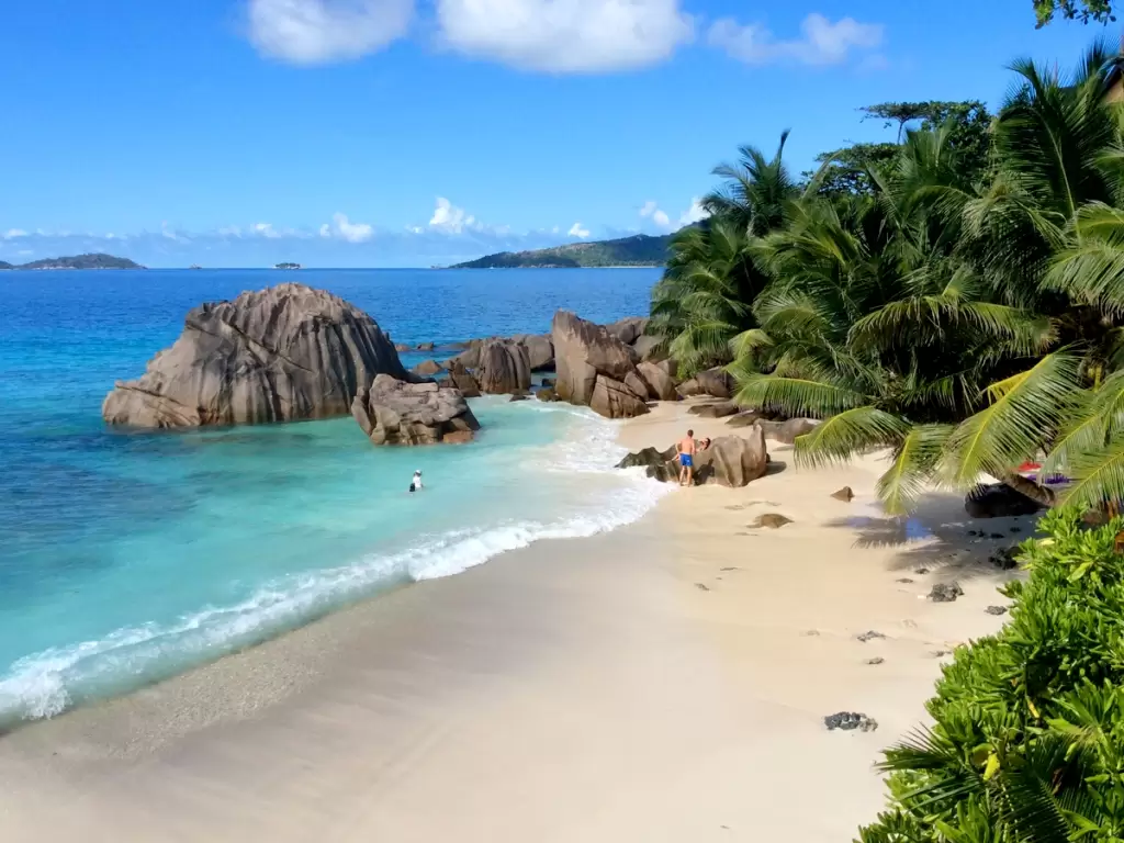 Breathtaking Anse Source D’Argent in Seychelles, with its powdery white sands, turquoise waters, dramatic granite boulders, and lush palm-fringed shoreline.