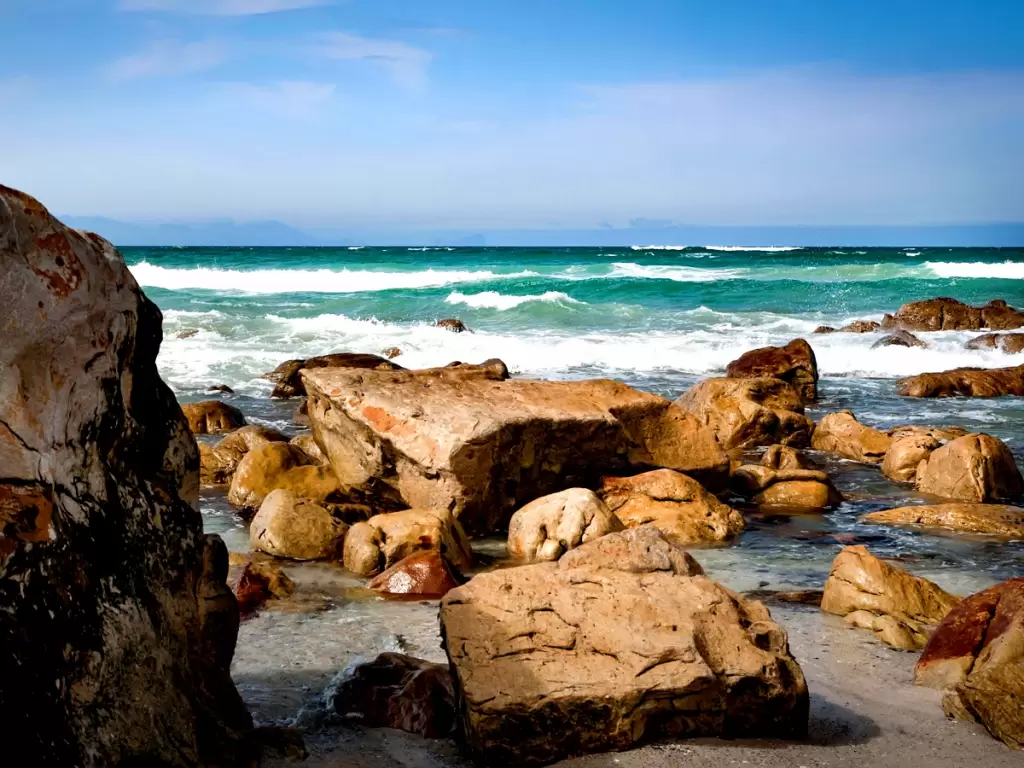 Scenic rocky shores and turquoise waters under blue sky at a South African beach 2025/2026.