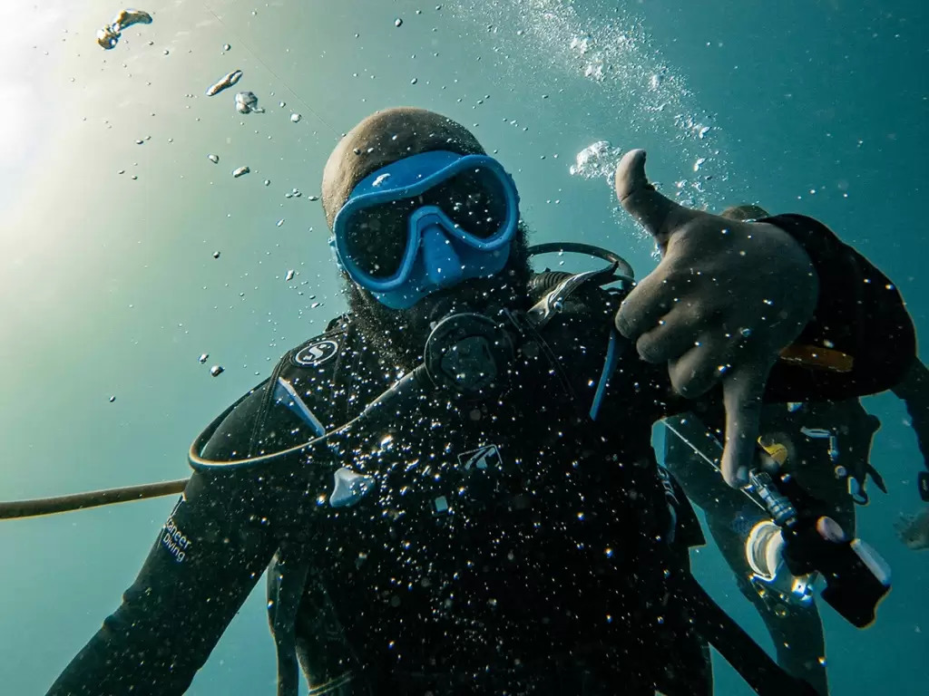 Underwater scuba diver showing a thumb up in Mjini Magharibi region, Zanzibar, Tanzania. 
