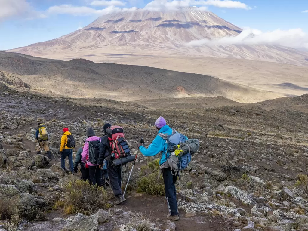 Group of trekkers surrounded by rugged landscapes on Mount Kilimanjaro trek in Tanga region, Tanzania.