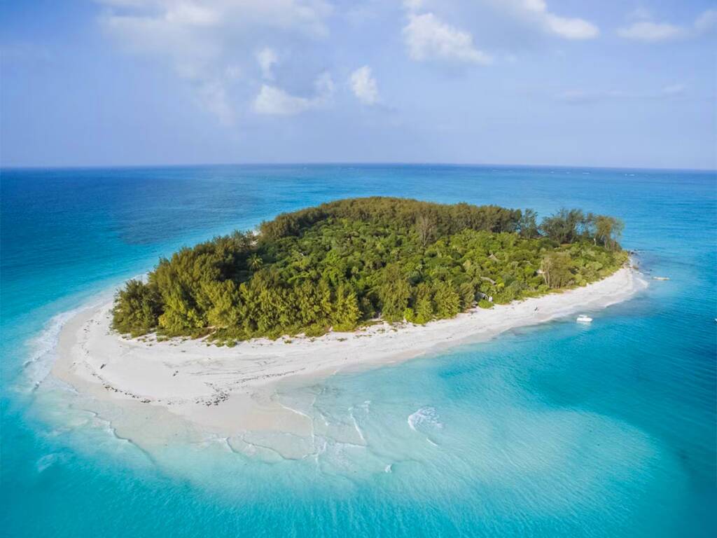 Mnemba Island in Zanzibar with white sand beach and turquoise waters, for a luxury beach retreat.