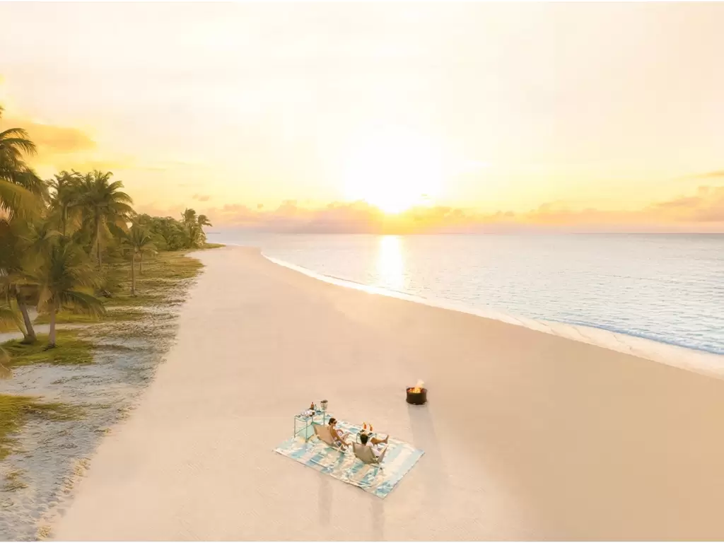 A romantic couple relaxing at sunset with a cozy bonfire, on private, sandy beaches of Madagascar, on a luxury African holiday.
