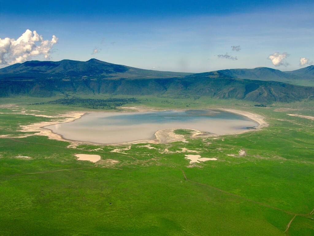 Aerial view of the Ngorongoro Crater, Tanzania, with vast, lush landscape and volcanic caldera.