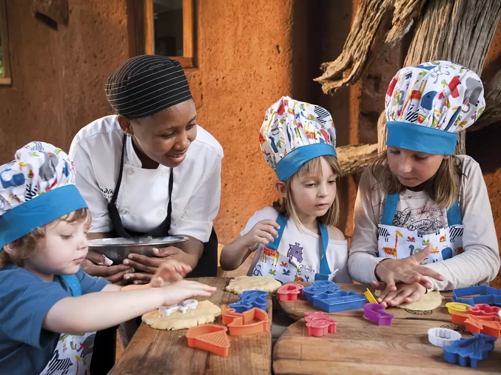 Children enjoy a guided baking activity with an African safari lodge chef.