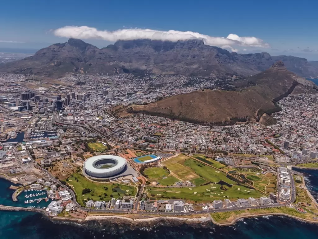 Cape Town, South Africa with Table Mountain in the backdrop, the bustling city, and Kruger National Park in the distance. 